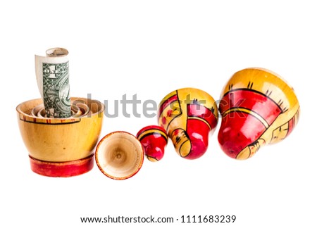 Russian doll with dollars inside isolated on white background