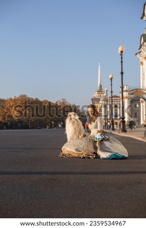Russian elegance at sunrise: A lady in Tsarist-era attire surrounded by white Borzoi dogs on Palace Square, St. Petersburg, with Admiralty Spire in the backdrop