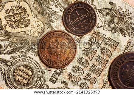 Russian Empire coins and vintage paper 10 rubles money note of 19th cent. Top view of old copper coins of Russia. Concept of antique currency, historical rare banknote, coat of arms and numismatics.