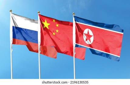 Russian Flag With Chinese Flag And North Korean Flag On Cloudy Sky. Waving In The Sky