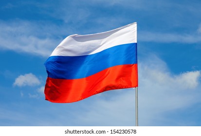 Russian Flag Waving In The Wind Over Blue Sky