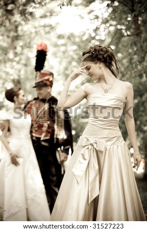 Russian hussar in vintage outfit with pretty women.
