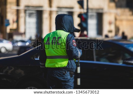 Russian Inspector of traffic police highway patrol regulates the movement of transport in the center of Moscow, in yellow vest jacket with a sign 