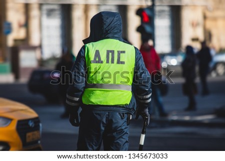 Russian Inspector of traffic police highway patrol regulates the movement of transport in the center of Moscow, in yellow vest jacket with a sign 