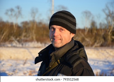 Russian Man In The Street In Winter Clothes Smiles Lit By The Sun. Leningrad Oblast, Russia