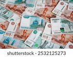 Russian money rubles in denominations of five thousand Russian rubles and one thousand Russian rubles are scattered all over the photograph, the background is made of money