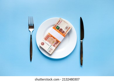 Russian Money Rubles On A White Plate With A Fork And A Knife On A Blue Background With A Denomination Of Five Thousand Rubles With A Bank Tag