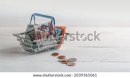 Russian paper and metal money in a shopping cart from a supermarket. Sales and purchases. Copy space.