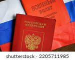 Russian passport, Certificate of Russia serviceman and flag on table, top view. Concept of mobilization, war in Ukraine, service, duty and army. Translation: Russian Federation, Military ID card.