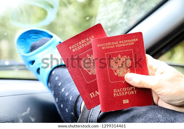 Russian passport in the hand of an elderly woman\
sitting in the car