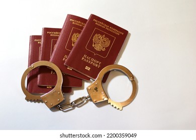 Russian Passport And Handcuffs On A White Background. Prohibition Of Russian Citizens On Entry And Exit. Passport Lock