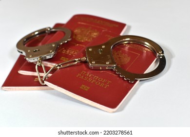 Russian Passport And Handcuffs On A White Background. Prohibition Of Russian Citizens On Entry And Exit. Passport Lock