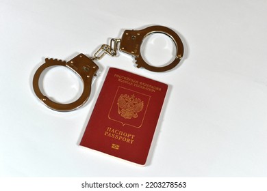 Russian Passport And Handcuffs On A White Background. Prohibition Of Russian Citizens On Entry And Exit. Passport Lock