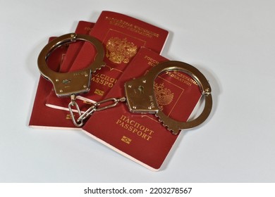 Russian Passport And Handcuffs On A White Background. Prohibition Of Russian Citizens On Entry And Exit. Passport Lock