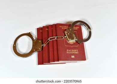 Russian Passport And Handcuffs On A White Background. Prohibition Of Russian Citizens On Entry And Exit. Passport Lock