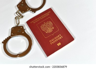 Russian Passport And Handcuffs On A White Background. Prohibition Of Russian Citizens On Entry And Exit. Passport Lock