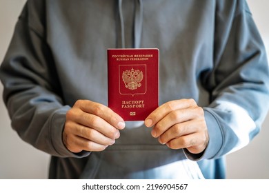 Russian passport in the hands of a man. Prohibition of Schengen visas for Russian tourists to travel to the European Union concept. - Shutterstock ID 2196904567