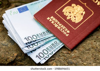 In the russian passport lies a pack of euros lying on the street. Inscription in Russian passport of the Russian Federation - Shutterstock ID 1988696651