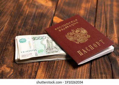 Russian Passport With Money For Shopping Abroad, Travel And Entertainment. Money Is Lying On Wooden Background.