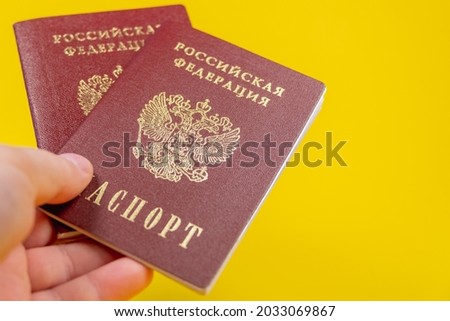 Russian passport, transliteration: Passport of the Russian Federation. A human hand with a Russian passport in close-up. The concept of obtaining citizenship of the Russian Federation. Close-up.