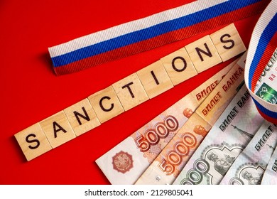 Russian ruble banknotes issued by the Bank of Russia on red background with Russian flag ribbon. Russian ruble under sanctions.
