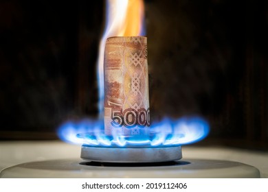 Russian ruble is burning in the fire. concept the rise in the price of gas in Russia. a bill of 5000 rubles burns in a fire on a gas stove. Expensive gas supply