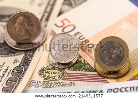 Russian ruble coin, dollar and euro coins, euro, dollar, ruble banknotes. Confrontation of Russian Ruble and dollar, euro