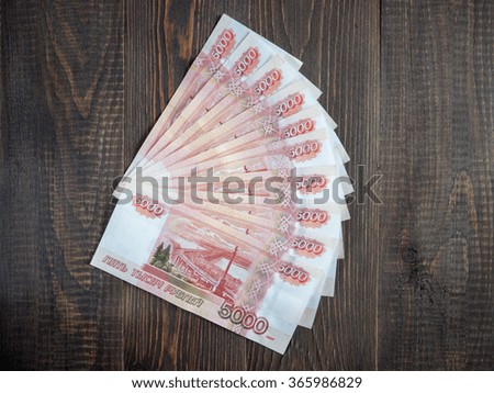 Russian ruble five thousandth banknotes on wood background