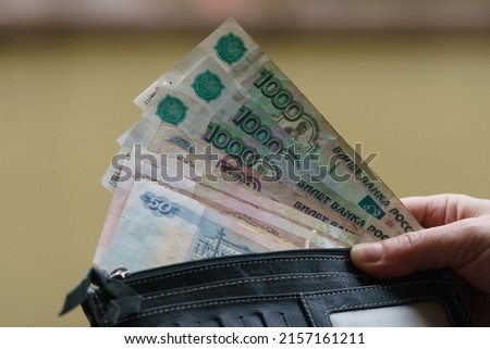 Russian Rubles image. Banknotes of 1000, 500, 100, 50 rubles. Human hand holding wallet with banknotes