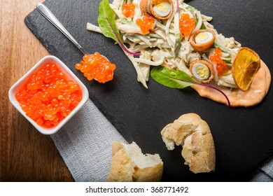 Russian salad - Olivier at home with a spoon of red caviar