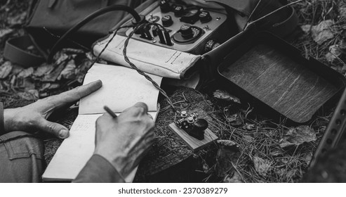 Russian Soviet Infantry Red Army Soldier In World War II using Russian Soviet Portable Radio Transceiver In Trench Entrenchment In Spring Autumn Forest. . Headphones And Telegraph Key. Close Up Hands,