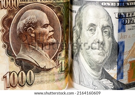 The Russian Soviet ruble and 100 of American dollars. confrontation between the capitalist and socialist systems. Cold War. Portraits of Vladimir Lenin and Benjamin Franklin on the national currency.