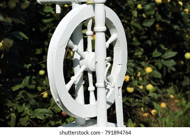 Russian Spinning Wheel Is Painted White. In The Apple Orchard.