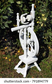 Russian Spinning Wheel Is Painted White. In The Apple Orchard.