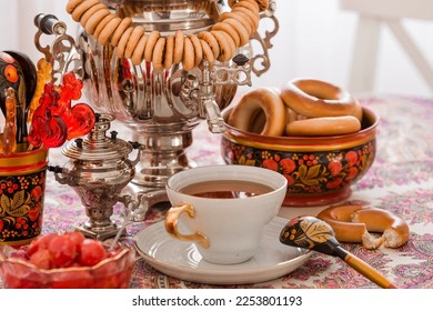 Russian traditions. Tea drinking with a samovar. Still life with a cup of tea, bagels, dried fruits, apple jam, caramel cockerel and Russian samovars.