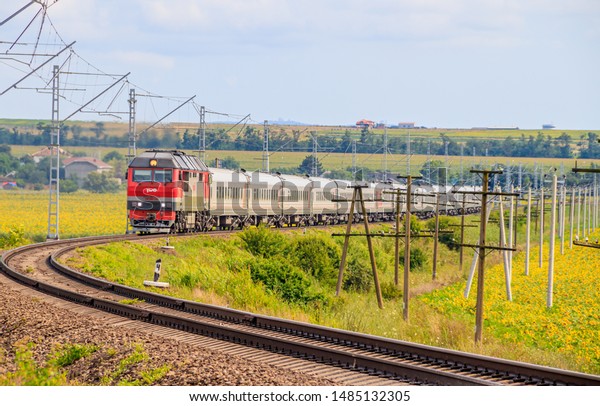 The Russian train travels by rail. Passenger train\
rides through the fields. Russian railway. locomotive. Russia,\
Anapa, July 16, 2019