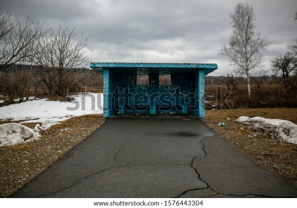 Russian village.\
Concrete public transport stop without people in the middle of a\
road in a Russian\
village
