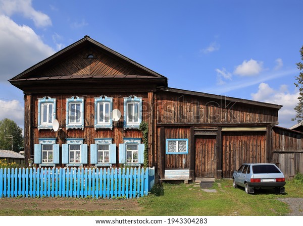 Russian village in summer. View of the old\
traditional two-storey wooden houses with carved windows. Village\
of Visim, Sverdlovsk oblast, Urals,\
Russia.