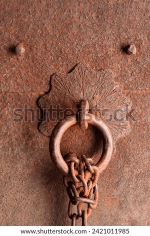 Rust metallic massive door with ring and rusted chain