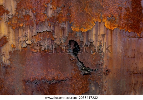 Rust of\
metals.Corrosive Rust on old iron with a hole. Rusted orange\
painted metal wall. Rusty metal background with streaks of rust.\
Old shabby paint.metal rust texture\
background