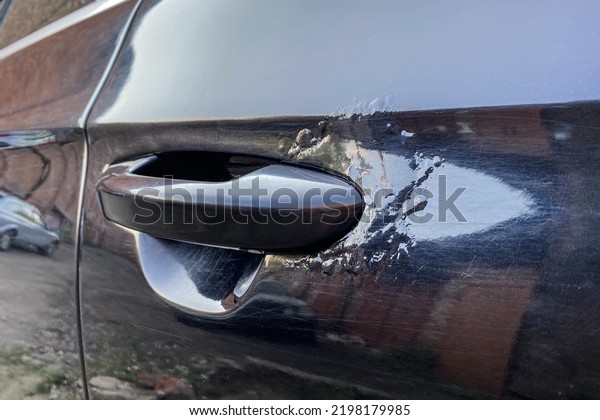 rust is on door near\
door handle on the car. rusty car door. car needs painting.\
blistered paint from rust