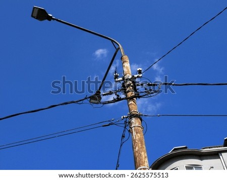 Rust on the Pole and Wires Dangerously Tangled Against a Crisp Blue Sky in Belgrade (Serbia)