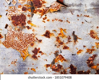 Rust on the side of white old car. Rust hole on old worn painted metal surface