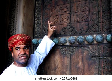 RUSTAQ, OMAN - DEC 23 2007:Omani tour guide explain the meaning of Arab words on the gate of Al Hazm Fort.Arabic is a Semitic language, date back to AD 512-568 closely related to Aramaic and Hebrew.