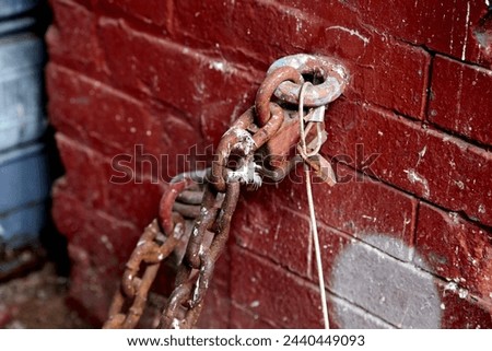 Rusted Chain Locked to Red Brick Wall