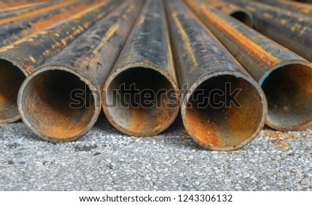 rusted construction pipe laid on asphalt 