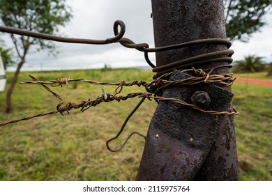 Rusted Farm Fence Post With Barbed Wire Holding On. Showing The Rustic Farm Living.