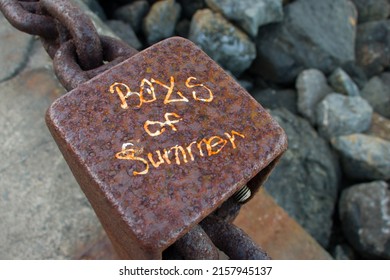 Rusted Fence Post Near The Bay With Graffiti