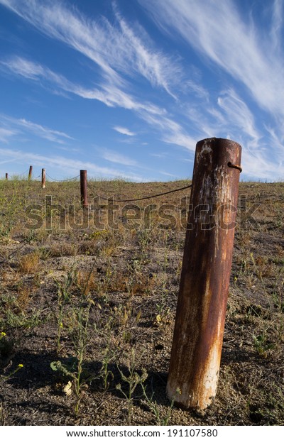 The\
rusted fence post in the Southern California\
desert.
