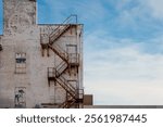 Rusted fire escape on facade of old industrial building